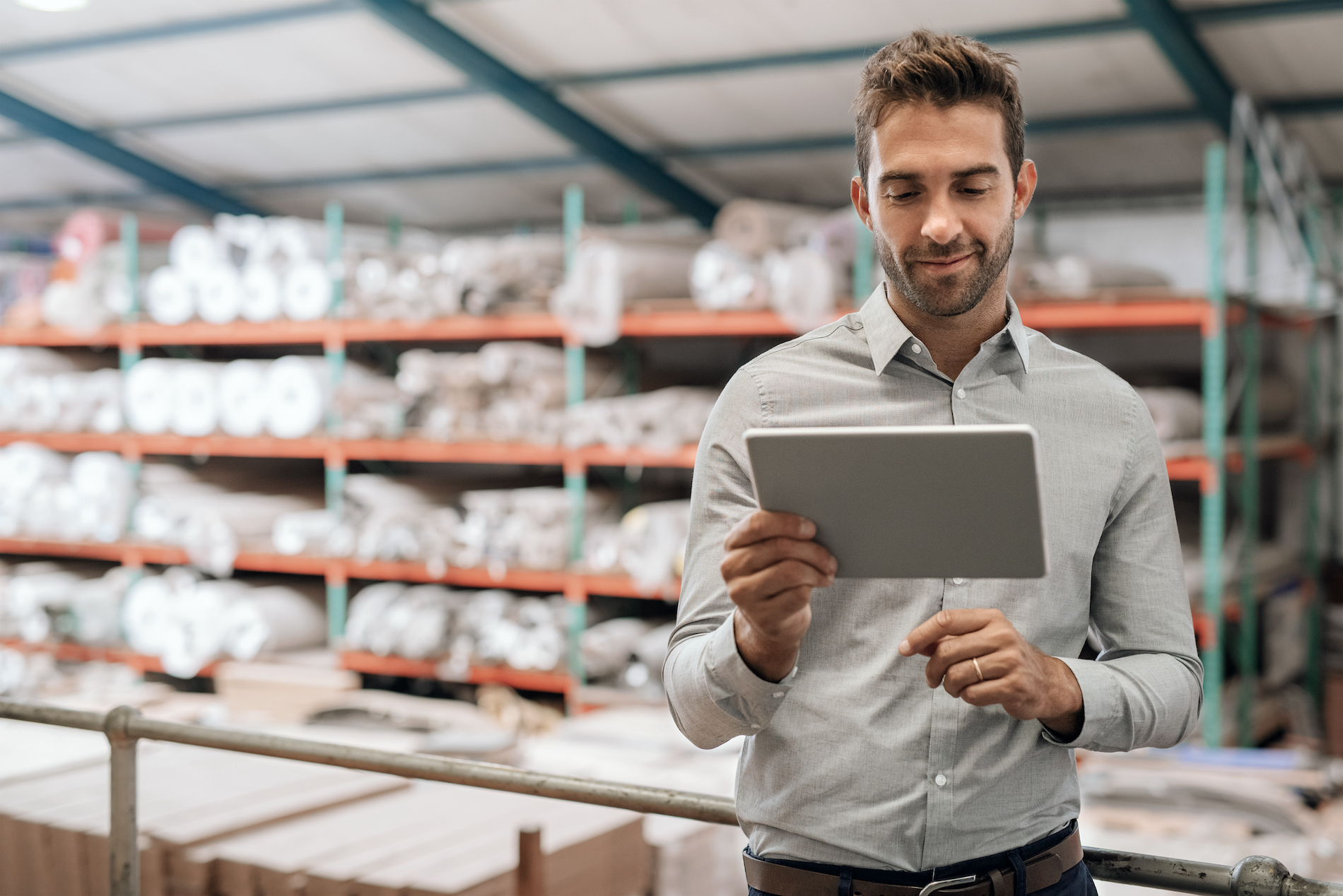 Distribution Warehouse Cloud Technology Happy distribution warehouse manager holding a cloud-enabled mobile tablet