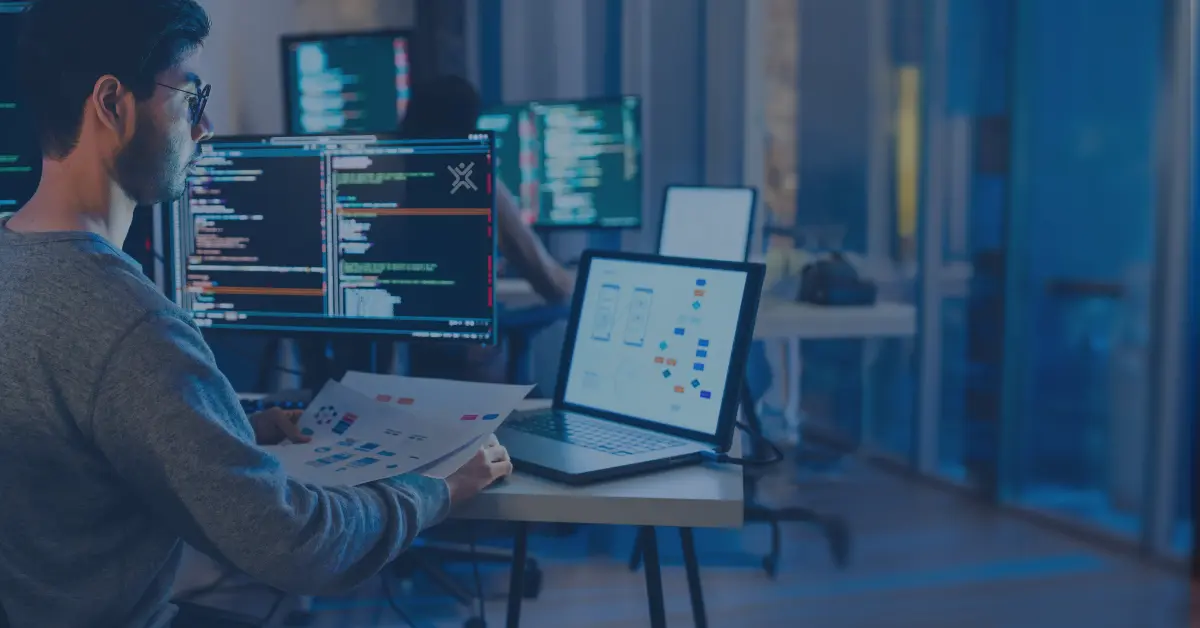 ERP integration specialist reviewing EDI workflows and business data across multiple computer screens.<br />
